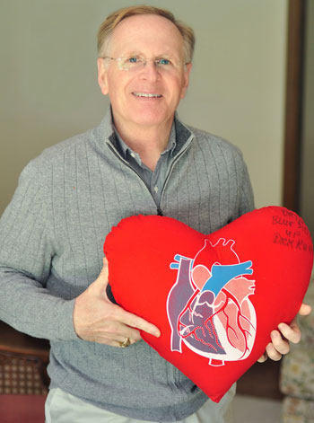 David Hooper Holding A Big Red Heart Pillow