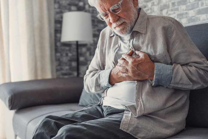 Older man holding chest in pain